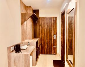 マナリにあるRaman Guest Houseのバスルーム(木製の壁、シンク付きのカウンター付)