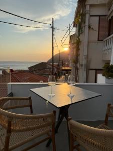 two wine glasses on a table with a view of the ocean at Michalelis Loft & Cave in Plomari