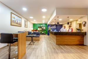a restaurant with a counter with two people in the background at Daher Center Hotel in São Paulo