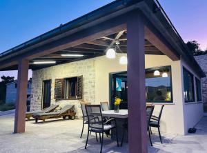 a patio with a wooden pergola and a table and chairs at Milton holiday house in Blato
