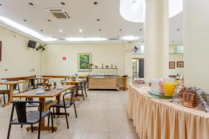 a restaurant with tables and chairs and a counter at Daher Center Hotel in São Paulo