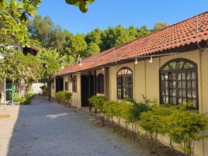 a building with a red roof and a pathway at Pousada Ilha do Sol in Florianópolis