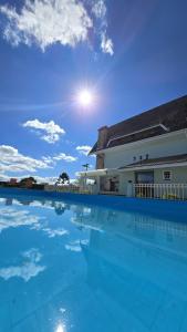 a large swimming pool in front of a building at Pousada Villa Dolce Amore - Boutique Hotel in Campos do Jordão