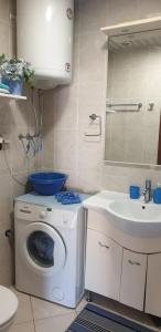 ein Badezimmer mit Waschmaschine und Waschbecken in der Unterkunft Meri in Bar + 20 Fotos