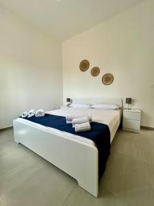une chambre avec un grand lit avec des serviettes dessus dans l'établissement Sunshine Apartment Acireale, à Acireale