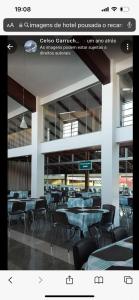 a restaurant with tables and chairs in a building at Hotel O Recanto in Campo Mourão