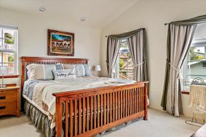 ein Schlafzimmer mit einem Holzbett und Fenstern in der Unterkunft A Dolphin Dreams in Cambria