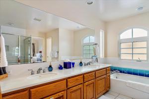 ein Badezimmer mit zwei Waschbecken, einer Badewanne und einer Badewanne in der Unterkunft A Dolphin Dreams in Cambria