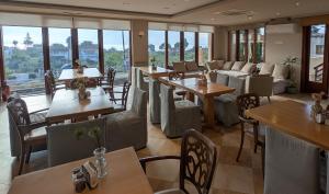 a restaurant with tables and chairs and windows at Althea Apartments in Katakolo