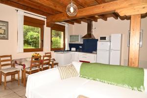 a bedroom with a white bed and a kitchen at La Palombrera in Treceño