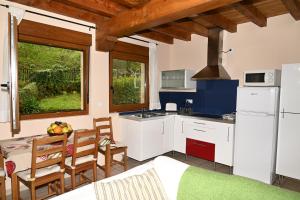 a kitchen with white cabinets and a table and chairs at La Palombrera in Treceño