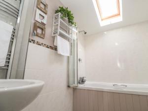a white bathroom with a sink and a bath tub at Tremar in St Ives +18 photos