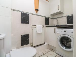 a bathroom with a washing machine and a washer at Tremar in St Ives
