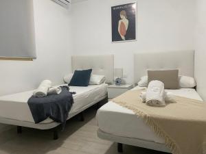 two beds sitting next to each other in a room at Apartamento ensueño 1a linea playa poniente 6 PAX parking wifi y AC in Benidorm +30 photos