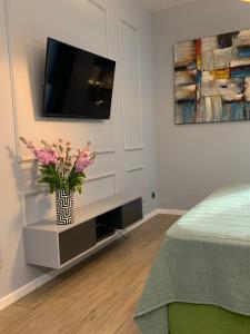 a bedroom with a tv and a vase of flowers at Rajska 3 in Kraków