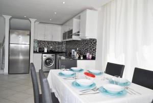 mesa de comedor con mantel blanco y platos azules en Villavoyn, en Fethiye