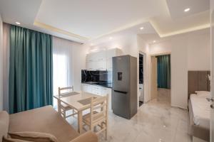 a kitchen and living room with a table and a refrigerator at Apartments Mario in Ksamil