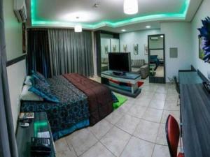 a hotel room with a bed and a television at Hotel O Recanto in Campo Mourão