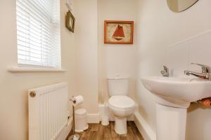 a white bathroom with a sink and a toilet at Rails End in Whitby +32 photos