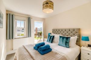 a bedroom with a large bed with blue pillows at Rails End in Whitby