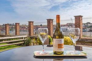 a bottle of wine and two glasses on a table at Rails End in Whitby