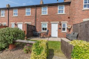 a brick house with a garden in front of it at Rails End in Whitby