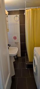 bagno con tenda doccia gialla e servizi igienici di Onix 4 ad Atene