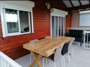 una mesa de madera y sillas en un porche en Villa Bien-Désiré, en Saint-François