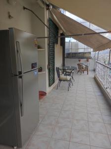 un frigorifero su un balcone con tavolo e sedie di Onix 4 ad Atene