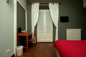 コモにあるB&Bレジデンツァカヴールのデスク、カーテン付きのドアが備わる客室です。