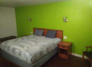 a green bedroom with a bed and a night stand at 2 Double Beds Hotel Studio 134 in Livingston