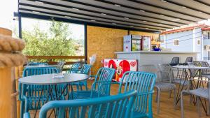 an empty restaurant with blue chairs and tables at Apartments Mario in Ksamil