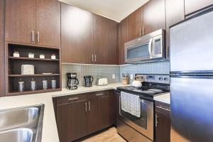 a kitchen with stainless steel appliances and wooden cabinets at Spacious 2BDR Condo near Venice Beach in Los Angeles +8 photos