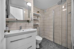 une salle de bain avec un lavabo, des toilettes et une douche dans l'établissement Lovely city center apartment with amazing views and free parking!, à Tromsø 26 autres photos