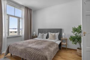 une chambre avec un grand lit avec une grande fenêtre dans l'établissement Lovely city center apartment with amazing views and free parking!, à Tromsø