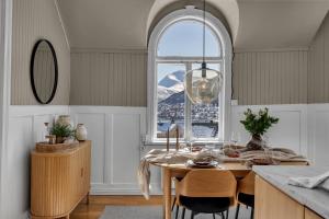 une cuisine avec une table et une grande fenêtre dans l'établissement Lovely city center apartment with amazing views and free parking!, à Tromsø