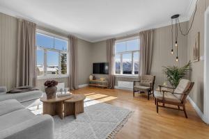 un salon avec un canapé et une table dans l'établissement Lovely city center apartment with amazing views and free parking!, à Tromsø