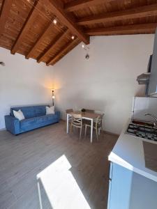 a living room with a blue couch and a table at BRES House in Porto Santo Stefano