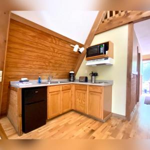 a kitchen with a sink and a microwave at A-Frame #02 - by The Chalets in Logan