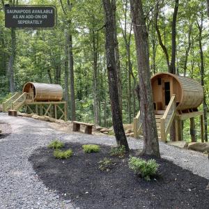 a wooden cabin in the woods with a tree at A-Frame #02 - by The Chalets in Logan