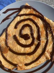 a waffle sitting on a plate with chocolate sauce at Un cocon en bord de mer in La Terre du Pont