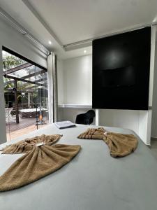 a bedroom with a bed with two towels on it at Casa com hidro privativa e área gourmet próximo ao Centro in Nova Friburgo