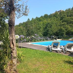 2 Liegestühle neben einem Pool in der Unterkunft Villa Natura in Cova