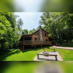 a log cabin with a bench in front of it at Dogwood - by The Chalets in Logan