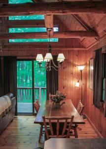 Un comedor con mesa y sillas de madera. en Elk - by The Chalets, en South Bloomingville