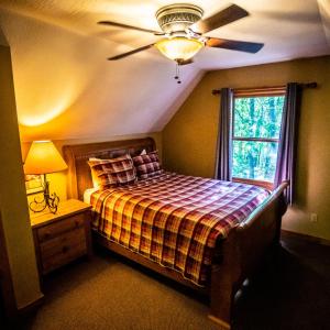 a bedroom with a bed with a ceiling fan and a window at Hawks Peak - by The Chalets in Logan
