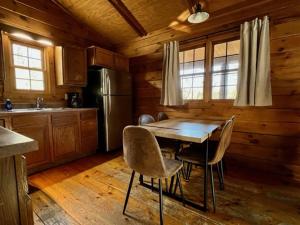 a kitchen with a table and chairs and a refrigerator at Hemlock - by The Chalets in Logan