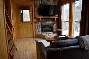 a living room with a couch and a fireplace at Pine Cone - by The Chalets in Logan