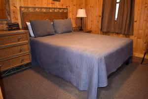 a bedroom with a bed and a dresser with a night stand at Pine Cone - by The Chalets in Logan +14 photos