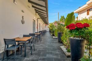eine Terrasse mit Tischen, Stühlen und roten Blumen in der Unterkunft Villa Perla in Marina di Massa